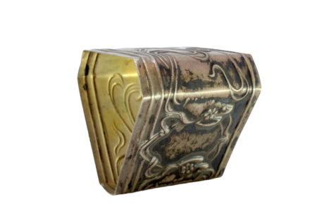 Argola de guardanapo em prata de forma triangular com laços e flores envolvendo cartela para monograma.